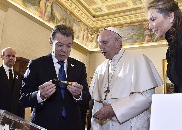 El Papa Francisco escucha la explicación que le hizo el Presidente Santos sobre el balígrafo que se creó como símbolo de la paz en Colombia.